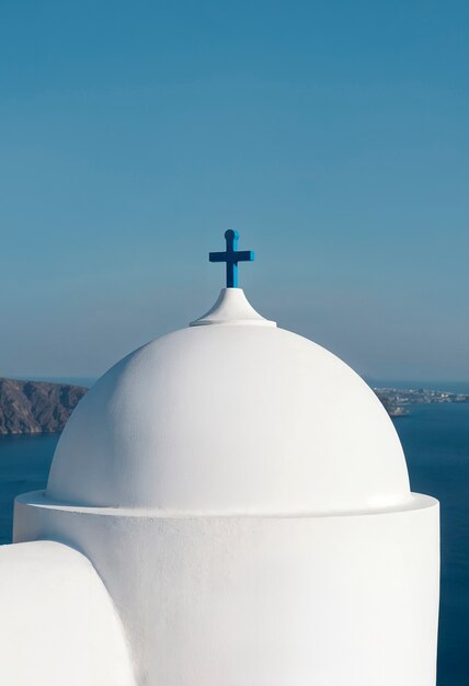 Church dome with a blue cross in santorini, greece