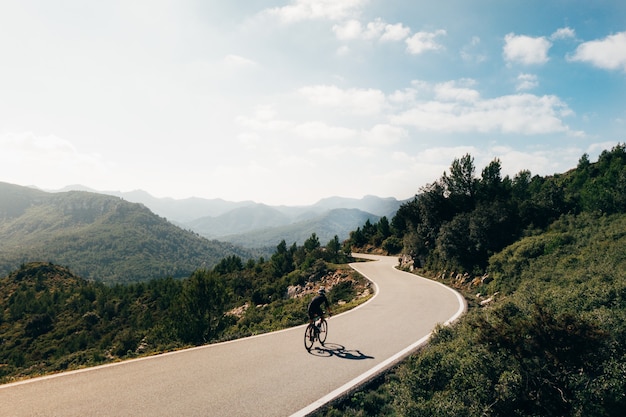 Foto gratuita ciclista en bicicleta al atardecer en una montaña roadoor