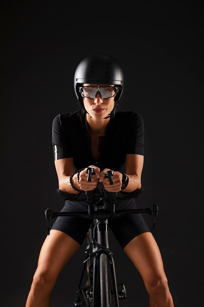 Ciclista femenina posando con bicicleta y casco
