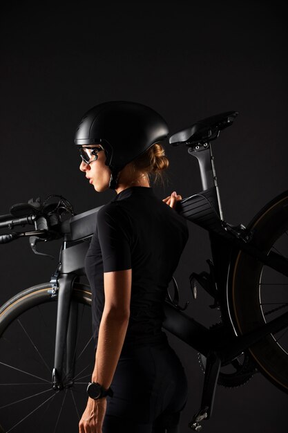 Ciclista femenina posando con bicicleta y casco