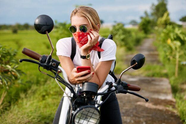 Ciclista femenina sentada junto a la moto