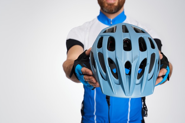 Ciclista irreconocible mostrando un moderno casco protector a la cámara