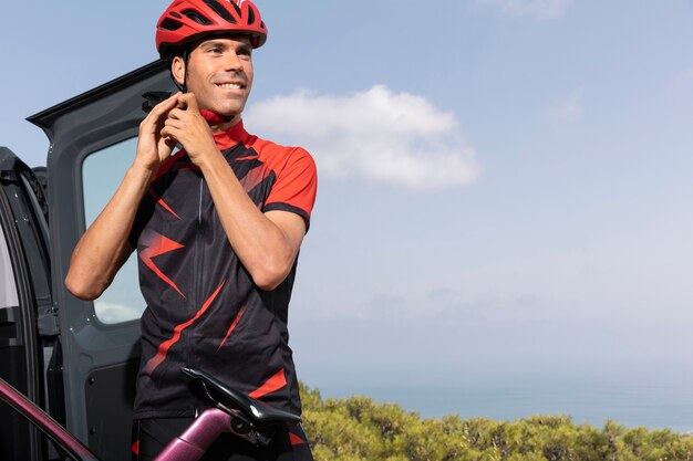 Foto gratuita ciclista masculino con bicicleta y casco al aire libre en la naturaleza