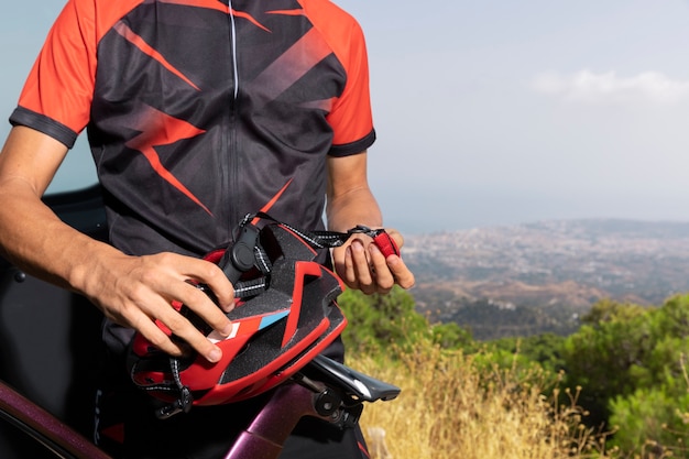Foto gratuita ciclista masculino con bicicleta y casco al aire libre en la naturaleza