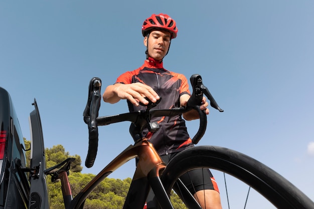 Foto gratuita ciclista masculino con bicicleta y casco al aire libre en la naturaleza