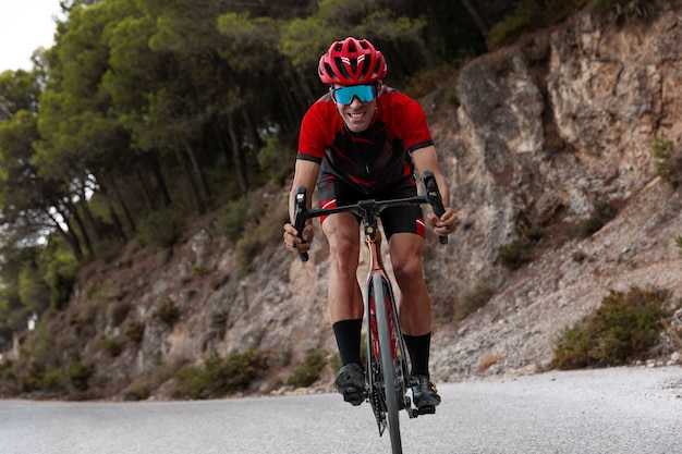 Ciclista masculino con casco entrenando en bicicleta al aire libre