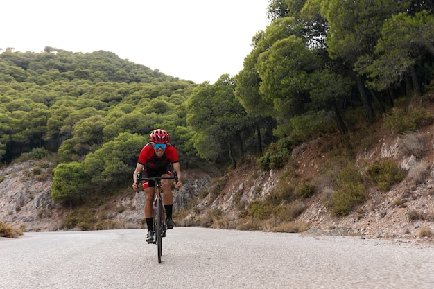 Foto gratuita ciclista masculino entrenando con bicicleta al aire libre