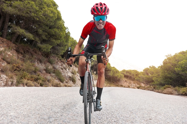 Foto gratuita ciclista masculino entrenando con bicicleta al aire libre