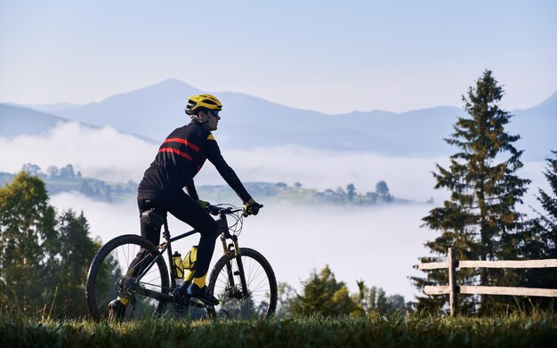 Ciclista masculino montando bicicleta en las montañas