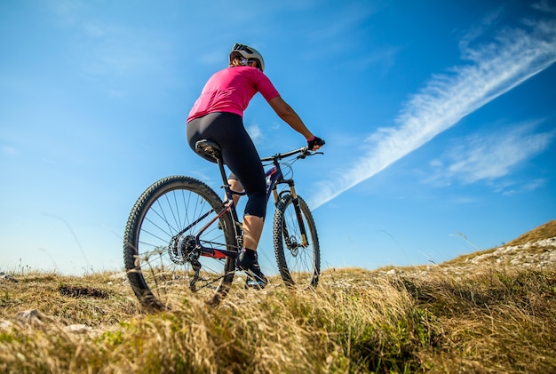 Ciclista de montaña femenino en la meseta de Nanos en Eslovenia en un día soleado