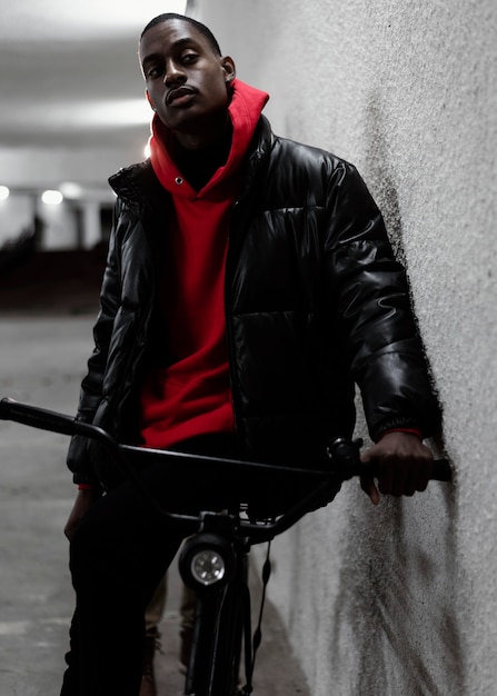 Foto gratuita ciclista urbano apoyado en una pared.