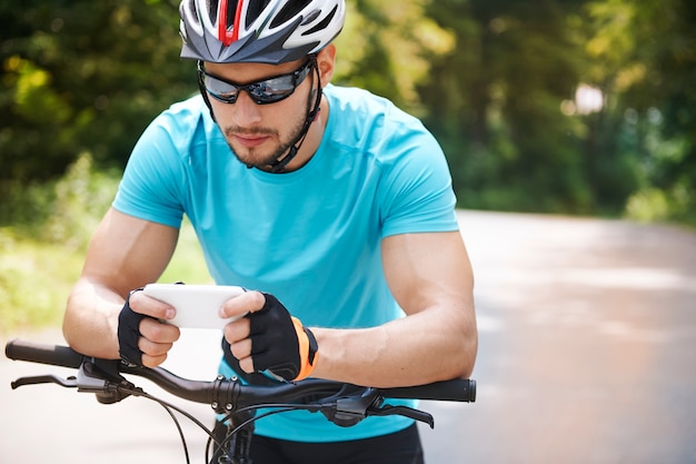 Ciclista usando su teléfono móvil