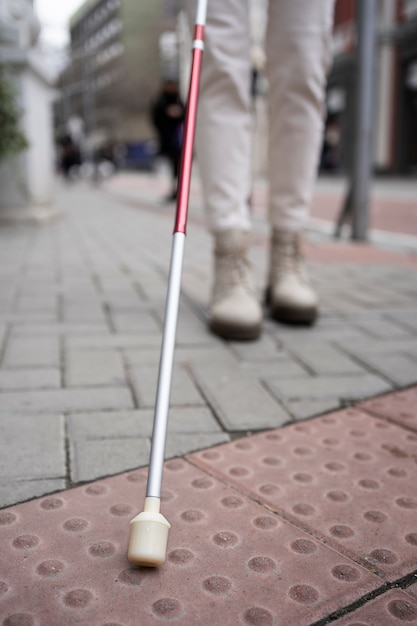 Foto gratuita ciego caminando por la ciudad con bastón ciego
