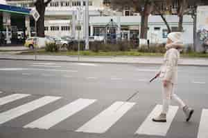 Foto gratuita ciego caminando por la ciudad con bastón ciego