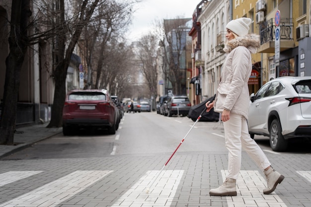 Foto gratuita ciego caminando por la ciudad con bastón ciego
