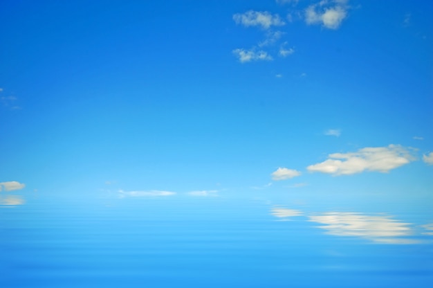 Cielo azul con nubes reflejado en el agua