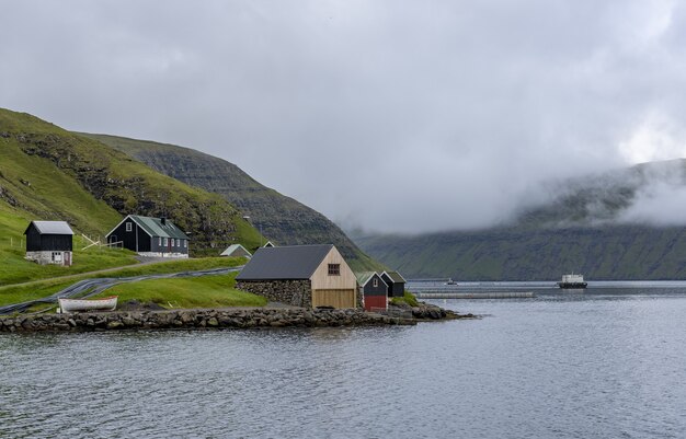 Cielo y casas en la orilla de las Islas Feroe