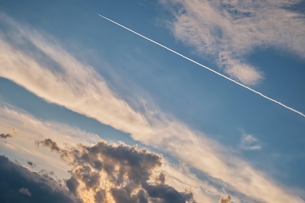 Foto gratuita cielo pretormentoso al atardecer rayado con franjas de condensación de aviones hermosa naturaleza problemas ambientales y económicos