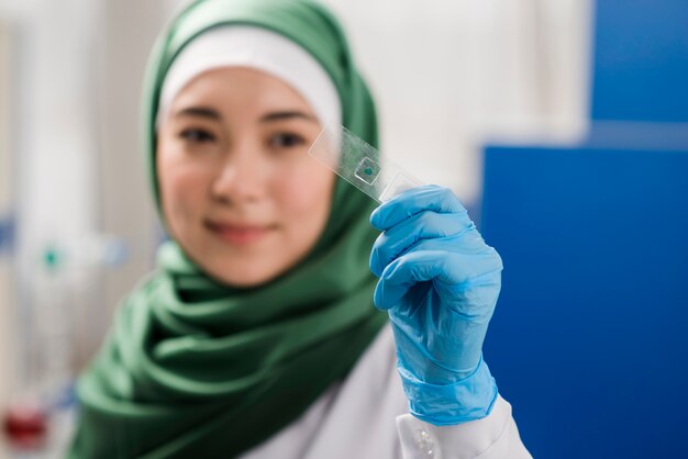 Científica desenfocada con hijab en el laboratorio