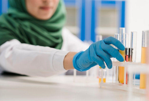 Científica desenfocada con hijab trabajando en el laboratorio