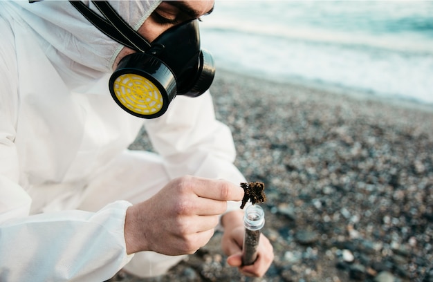 Foto gratuita cientifico analizando playa