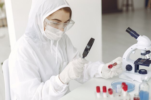 Científico en bata está examinando muestra de coronavirus en un laboratorio