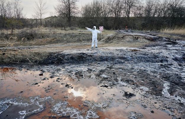 Foto gratuita científico explorando el área de emisión del territorio hombre de agua contaminada con traje protector