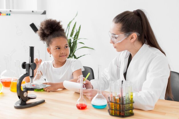 Científico femenino enseñando ciencia a niña