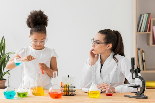 Científico femenino enseñando experimentos de ciencia a niñas