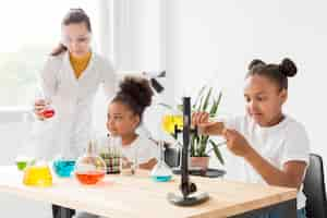 Foto gratuita científico femenino enseñando a las niñas sobre pociones de química