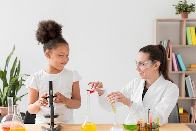 Científico femenino enseñando química a joven