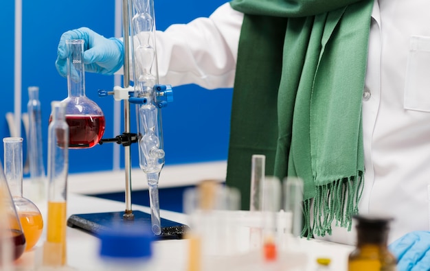 Foto gratuita científico femenino con hijab en el laboratorio con sustancia