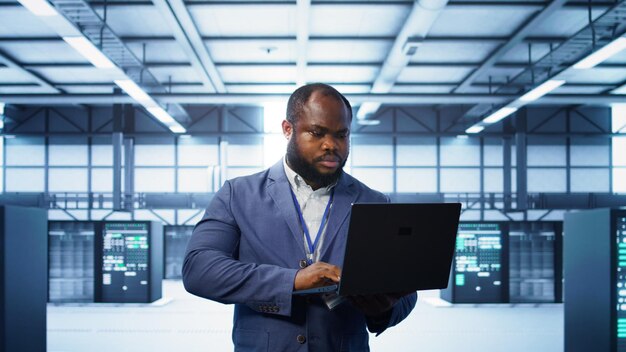 Científico informático en un centro de datos usando herramientas de diagnóstico en una computadora portátil