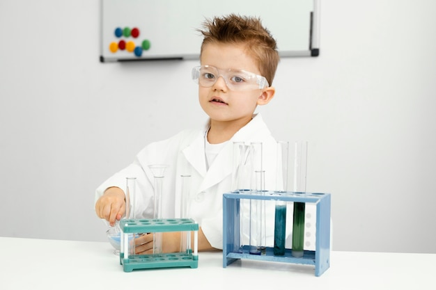 Foto gratuita científico lindo joven haciendo experimentos en bata de laboratorio