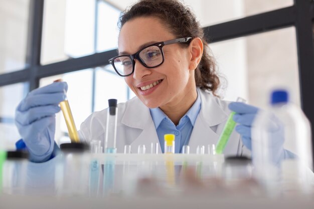 Científico sonriente sosteniendo el tubo de cerca