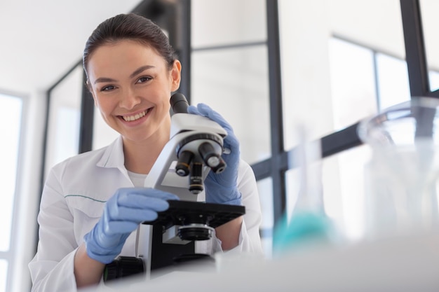 Científico de tiro medio trabajando con microscopio