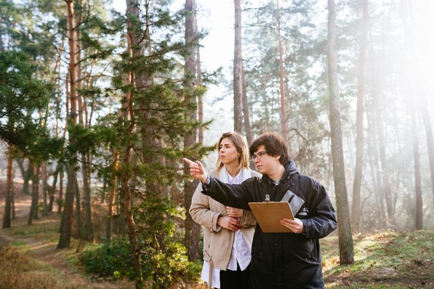 Los científicos estudian especies de plantas e inspeccionan árboles en el bosque.