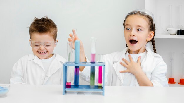 Los científicos del niño joven que se divierten haciendo experimentos en el laboratorio