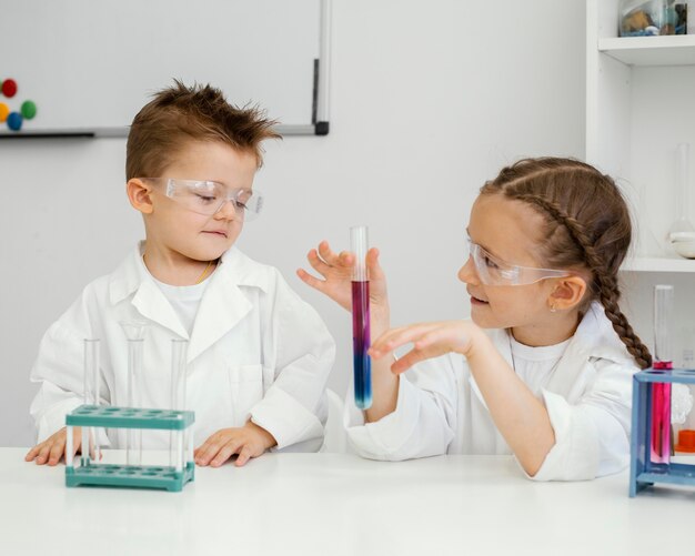 Científicos de niño y niña haciendo experimentos en el laboratorio