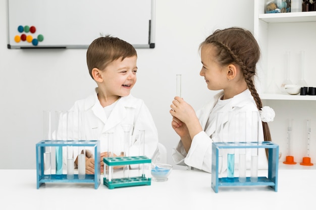 Foto gratuita científicos de niños pequeños lindos con tubos de ensayo