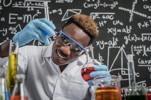 Los científicos observan los químicos azul cielo en vidrio en el laboratorio