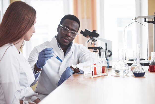 Los científicos trabajan en estrecha colaboración con el microscopio en el laboratorio realizando experimentos y análisis.