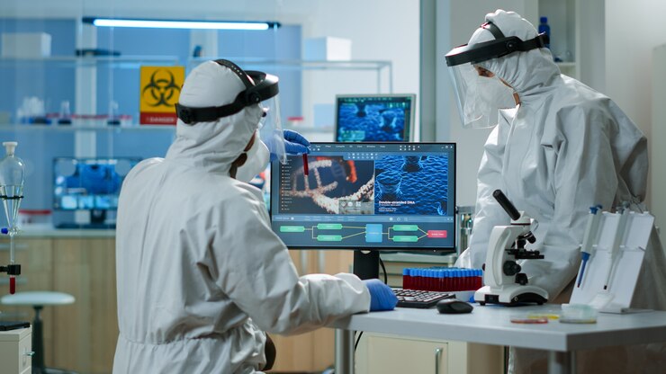 Foto gratuito científicos en trajes de protección analizando tubos de ensayo con muestra de sangre en laboratorio equipado con productos químicos. biólogos que examinan la evolución de las vacunas utilizando alta tecnología y tratamiento de investigación de tecnología