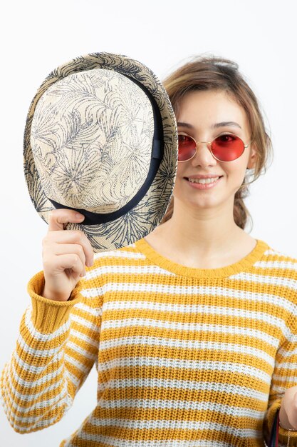 Cierra la foto de una mujer hermosa con sombrero y gafas posando. foto de alta calidad