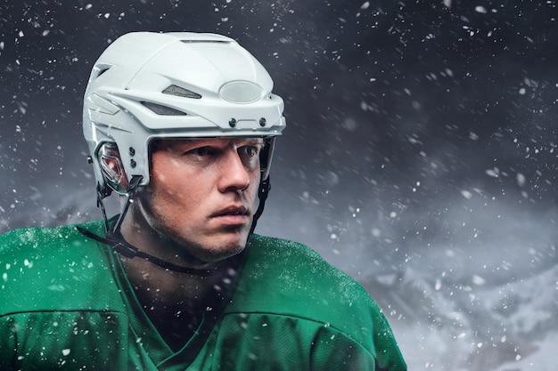 Cierra el retrato al aire libre del jugador de hockey en una tormenta de nieve.