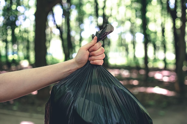 Foto gratuita cierre una bolsa de basura en un fondo borroso del bosque