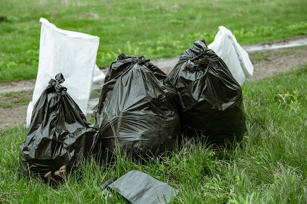 Cierre de bolsas de basura llenas de basura después de limpiar el medio ambiente.