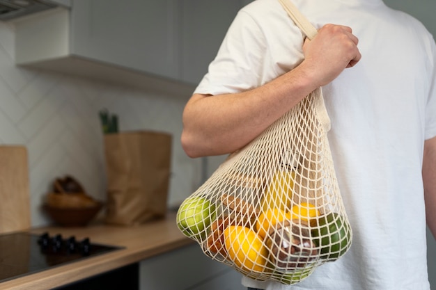 Cierre la mano que sostiene la bolsa de basura cero