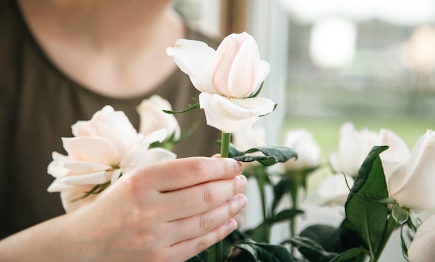 Cierre un ramo de rosas en manos de una florista femenina