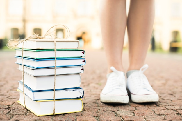 Ciérrese para arriba del adolescente que se coloca cerca de los libros